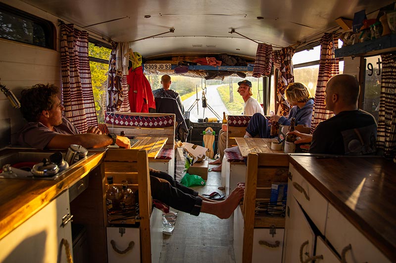 Les surfeurs bretons, allongés sur des sièges du Commodore Hostel, le bus réaménagé en surfcamp