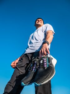 Benjamin Robert, en contre plongée, portant une paire de Nike Zoom Pegasus 38 dans ses mains.