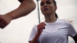 Portrait de Emilie Girard, en pleine course sur une piste d'athlétisme pendant une séance d'entrainement.