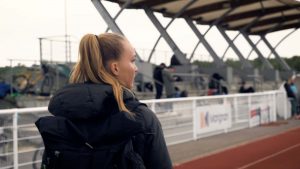 Emilie Girard arrive à pied sur la piste d'athlétisme, avant sa séance d'entrainement.