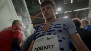 Contre-plongée de Benjamin Robert, en combinaison de compétition Nike Elite 2023, quittant la piste de l'Arena Stade Couvert de Liévin lors du meeting de Liévin 2024 après son 800m.